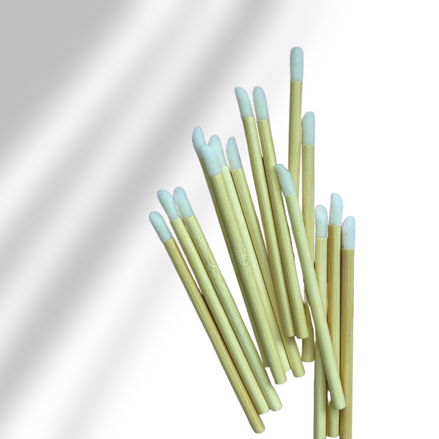 Bamboo disposable lip product application wands laying flat bunched together. 