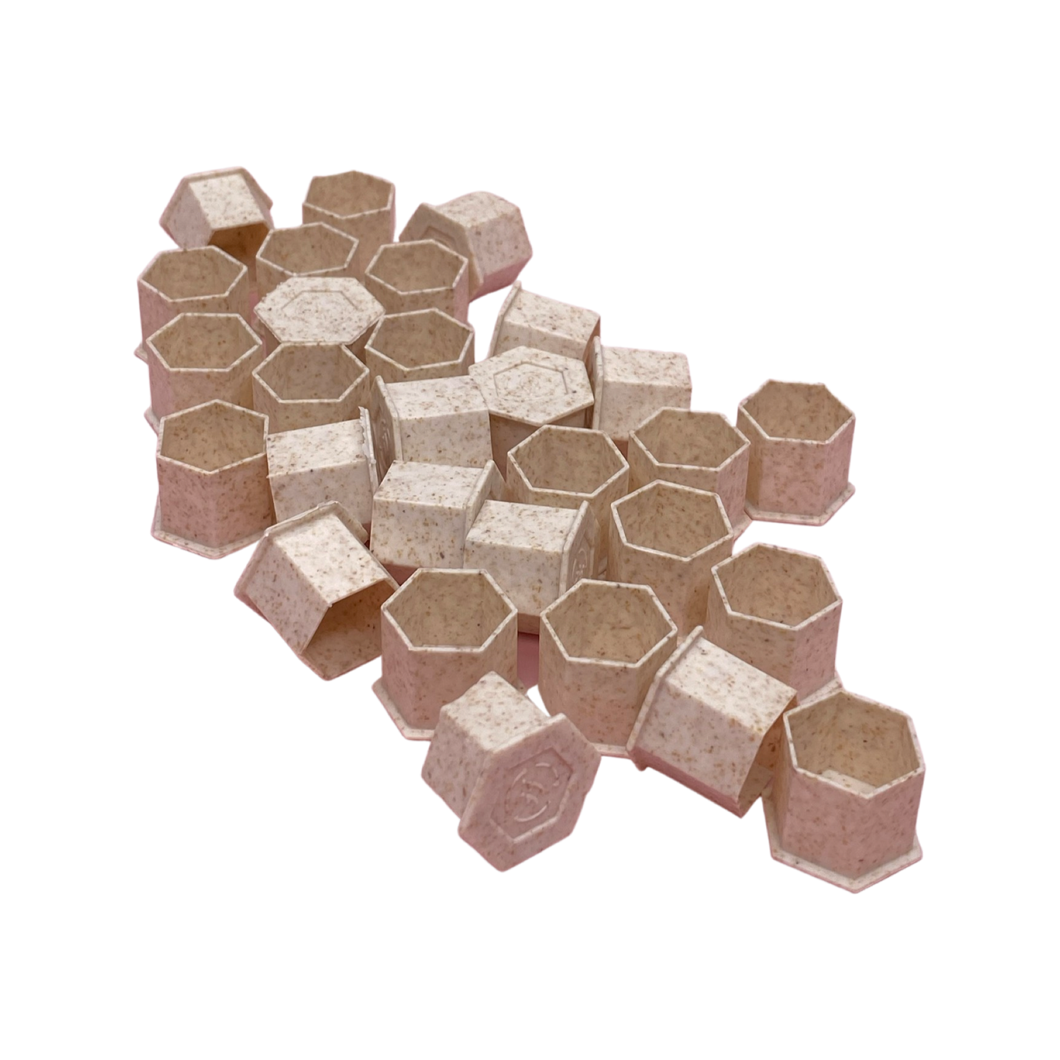Beige coloured biodegradable pigment cups with a flat base. In a cluster. 