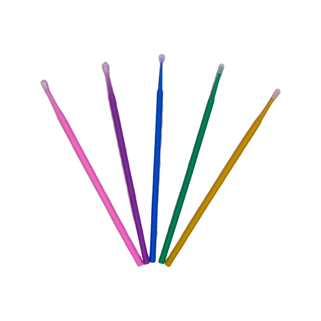 Five coloured micro brushes for lash and brow applications. Pink purple blue green and yellow laying flat fanned out. 
