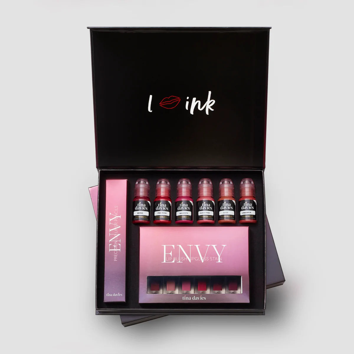 Tina davies ENVY lip collection in a black box. consists of 6 pigment bottles along the top row of the box, a long narrow box to the left and a rectangular box at the bottom with 6 matching lip gloss colors in them