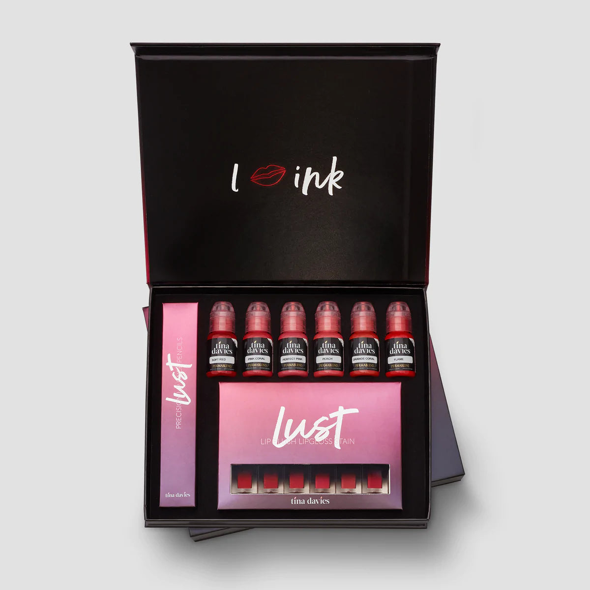 Tina davies lust lip collection in a black box.  consists of 6 pigment bottles along the top row of the box, a long narrow box to the left and a rectangular box at the bottom with 6 matching lip gloss colors in them